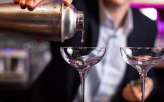 Barman pouring cocktail into glass